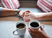 Manos enlazadas tomando café